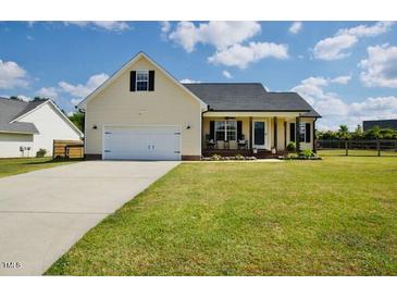 Charming single-story home with a well-manicured lawn, a two-car garage and inviting front porch at 50 Waterford Dr, Angier, NC 27501