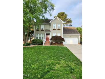 Charming two-story home with a well-manicured lawn and a welcoming red front door at 501 Samara St, Apex, NC 27502