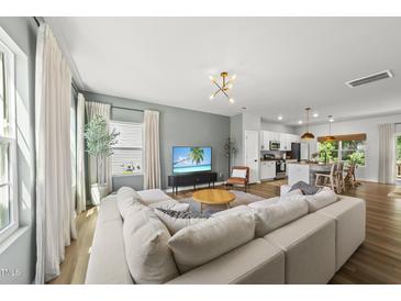 Bright, open-concept living room with a large sectional sofa and modern decor at 77 Rolling Creek Cir, Clayton, NC 27520