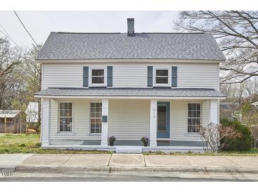 Charming two-story home featuring a covered front porch, gray shutters, and a well-maintained lawn at 913 Washington St, Durham, NC 27701