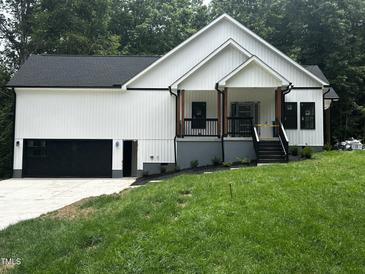 New construction with white siding, black trim, and a charming front porch at 101 Cochise Cv, Louisburg, NC 27549