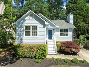 Charming light blue home features mature landscaping, white trim, and a brick foundation at 1040 Mills St, Raleigh, NC 27608
