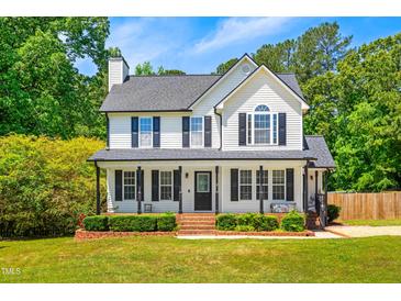 Charming two-story white home with black shutters, a brick walkway, and a beautifully landscaped front yard at 105 Kirkland Ct, Archer Lodge, NC 27527