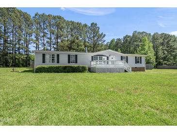 Charming one-story home with a white porch, complimented by a spacious lawn and bordered by trees at 109 Winding Creek Dr, Youngsville, NC 27596