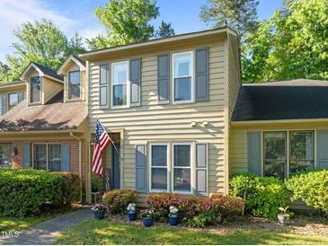 Charming two-story townhome with tan siding, gray shutters, and an American flag at 11 Stone Village, Durham, NC 27704