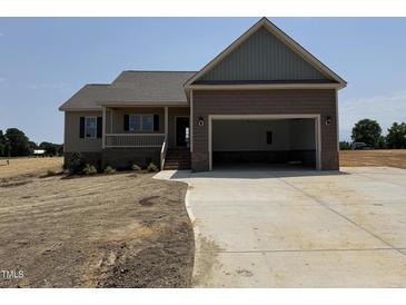 Charming single-story home featuring a two-car garage and covered front porch, all nestled on a spacious lot at 112 Royal Ave, Selma, NC 27576