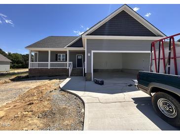 Charming single-story home featuring a covered porch, two-car garage, and fresh landscaping at 134 Royal Ave, Selma, NC 27576