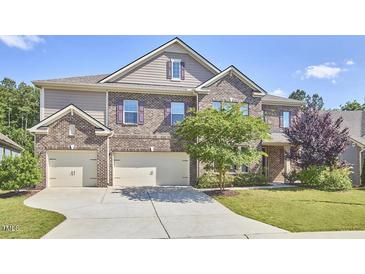 Charming brick home with a well-manicured lawn and a three-car garage at 1808 Capstone Dr, Durham, NC 27713