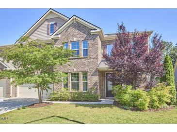 Charming two-story brick home featuring manicured lawn and lush landscaping, creating inviting curb appeal at 1808 Capstone Dr, Durham, NC 27713