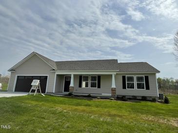 Charming single-story home with neutral siding, dark shutters and a two-car garage at 235 Starry Sky Dr, Benson, NC 27504
