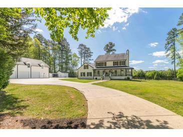 Charming two-story home with a welcoming front porch and a long driveway leading to a detached garage at 3010 Blueberry Ln, Chapel Hill, NC 27516