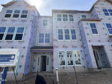 New construction townhome featuring large windows and modern architectural details at 327 Chesapeake Cmns St # 105, Garner, NC 27529