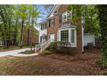 Charming brick and white home with lush landscaping and a welcoming front entrance at 3401 Scotch Dr, Raleigh, NC 27616