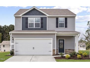 Charming two-story home featuring a two-car garage, stone accents, and a well-manicured lawn at 507 Benton Dr, Oxford, NC 27565