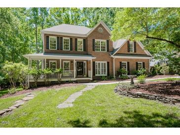 Charming brick home boasts a beautiful landscaped front yard and a welcoming porch at 5601 Jomali Dr, Durham, NC 27705