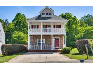 Charming two-story home boasts dual porches, stone accents, and mature landscaping at 5865 Forest Point Rd Rd, Raleigh, NC 27610