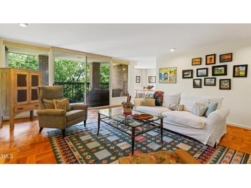 Bright living room featuring a white sofa, cozy chair, and balcony with scenic outdoor views at 620 Martin Luther King Jr Blvd # Apt 502, Chapel Hill, NC 27514