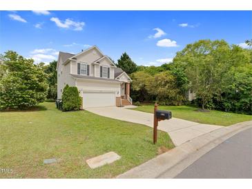 Charming two-story home with a well-maintained lawn, attached garage, and classic architectural details at 8820 Waynick Dr, Raleigh, NC 27617