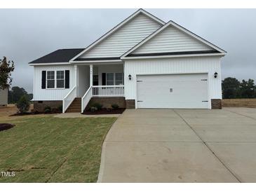 Charming, newly built one-story home with a white exterior, black shutters, and a two-car garage at 94 Royal Ave, Selma, NC 27576