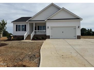 Charming single-Gathering home featuring a two-car garage, welcoming front porch, and modern farmhouse design at 94 Royal Ave, Selma, NC 27576