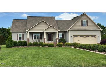 Charming single-Gathering home featuring a manicured lawn, neutral siding and an attached two-car garage at 107 Norwood Dr, Clayton, NC 27527