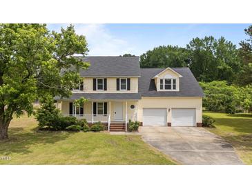 Charming two-story home featuring a welcoming front porch and an attached two-car garage at 114 Lynnville Ct, Lillington, NC 27546