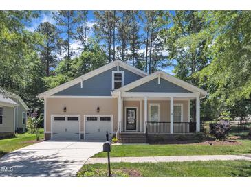 Charming home with a welcoming front porch, well-manicured lawn, and two-car garage at 151 Cobble Ridge Dr, Pittsboro, NC 27312