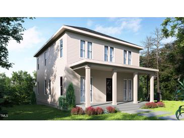 Two-story home with covered porch, neutral siding, and beautifully landscaped front yard at 203 E Winmore Ave, Chapel Hill, NC 27516
