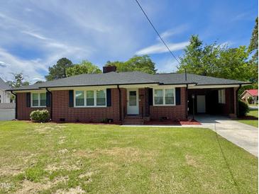 Charming brick home with a well-maintained lawn and blue sky at 213 N Brevard St, Selma, NC 27576