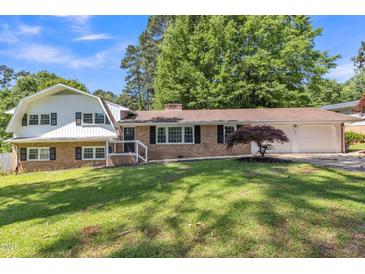 Charming two-story brick home with manicured lawn, attached garage, and beautiful mature trees at 2300 Radius Cir, Sanford, NC 27330