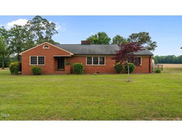 Charming single-story brick home with a well-manicured lawn and mature landscaping at 305 W Old Rd, Lillington, NC 27546