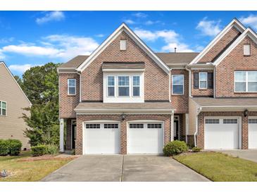 Charming brick townhome with a two-car garage and well-maintained landscaping at 416 Durants Neck Ln, Morrisville, NC 27560