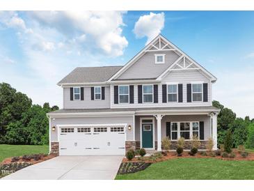 Beautiful two-story home with a two-car garage, landscaped yard, and inviting front porch at 488 Freedom Trail Dr, Willow Springs, NC 27592