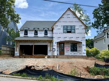 New two-story home featuring an attached two-car garage, a front door with a covered porch, and multiple windows at 521 Peebles St, Raleigh, NC 27608