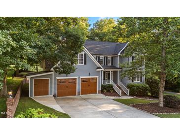 Charming two-story home with a three-car garage and well-manicured landscaping, nestled among mature trees at 905 Neuse Ridge Dr, Clayton, NC 27527