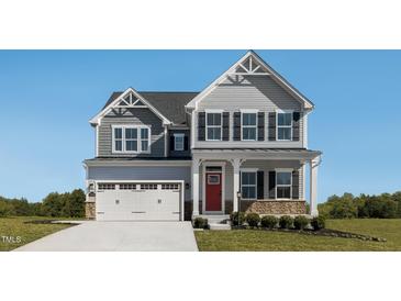 Charming two-story home with a two car garage, a manicured lawn and a striking red front door at 1012 Country Pasture Cv, Wendell, NC 27591