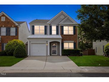 Charming two-story home featuring blue shutters, a one-car garage, and a well-maintained lawn at 107 Caraleigh Ct, Morrisville, NC 27560