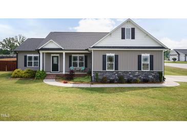 Charming single-story home boasts a manicured lawn and inviting covered porch at 18 Fisher Rd, Lillington, NC 27546