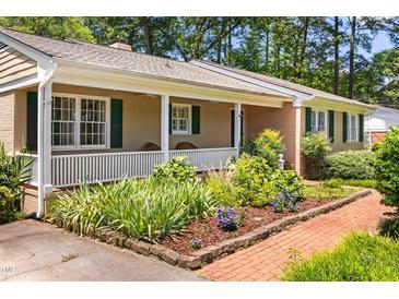 Charming home featuring a lovely front porch, well-manicured landscaping, and brick walkway at 2143 Ridge Rd, Raleigh, NC 27607