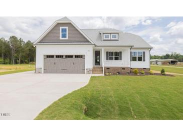 Charming single Gathering home with a 2-car garage, white siding, a covered porch and green grass at 24 Sanders Farm Dr, Smithfield, NC 27577