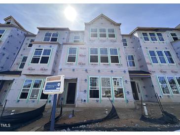 New construction townhome featuring multiple windows awaiting finishing touches, offering bright living spaces at 323 Chesapeake Cmns St # 104, Garner, NC 27529