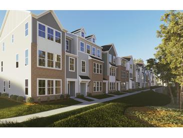 Beautifully designed townhomes showcase brick and siding exteriors, complemented by well-manicured lawns and landscaping at 335 Chesapeake Cmns St # 107, Garner, NC 27529
