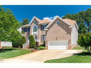 Charming two-story brick home with a well-manicured lawn and attached two-car garage at 4404 Triland Way, Cary, NC 27518