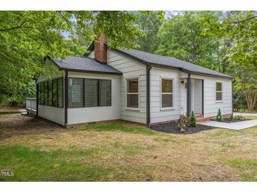 Charming white home with a sunroom, black trim, and a well-maintained lawn at 4713 Erwin Rd, Durham, NC 27705