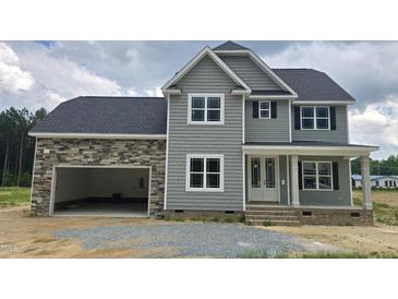 Charming two-story home featuring stone accents, neutral siding, double-hung windows, and an attached two-car garage at 48 Sanders Farm Dr, Smithfield, NC 27577
