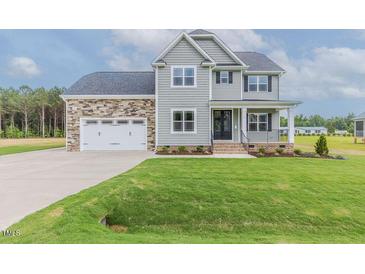 Charming two-story home with stone accents, attached two-car garage, and lush green lawn at 48 Sanders Farm Dr, Smithfield, NC 27577