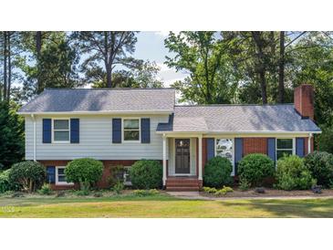 Charming two-story home with blue shutters, brick accents, and well-maintained landscaping at 4813 Glen Forest Dr, Raleigh, NC 27612