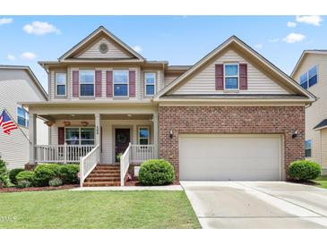 Inviting two-story home featuring a covered front porch, brick facade, and well-maintained landscaping at 508 Minerva Dale Dr, Fuquay Varina, NC 27526
