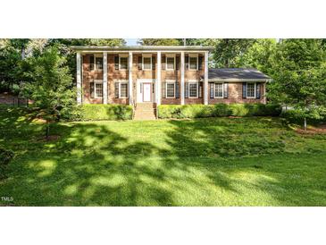 Classic brick home featuring stately white columns and a well-manicured front lawn at 5513 Parkwood Dr, Raleigh, NC 27612