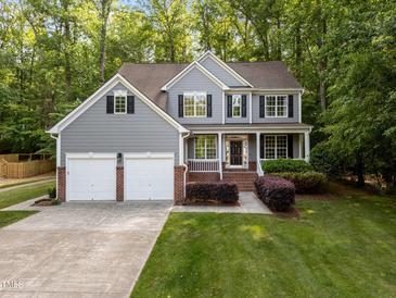 Two-story home featuring gray siding, black shutters, two-car garage, and a lush green lawn at 606 Churton Grove Blvd, Hillsborough, NC 27278